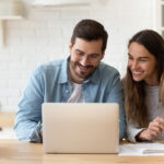 a couple looking at a laptop while financial planning