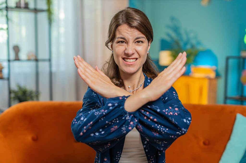 girl crossing arms and saying no in front of a computer