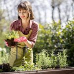 a woman holding a plant in her garden