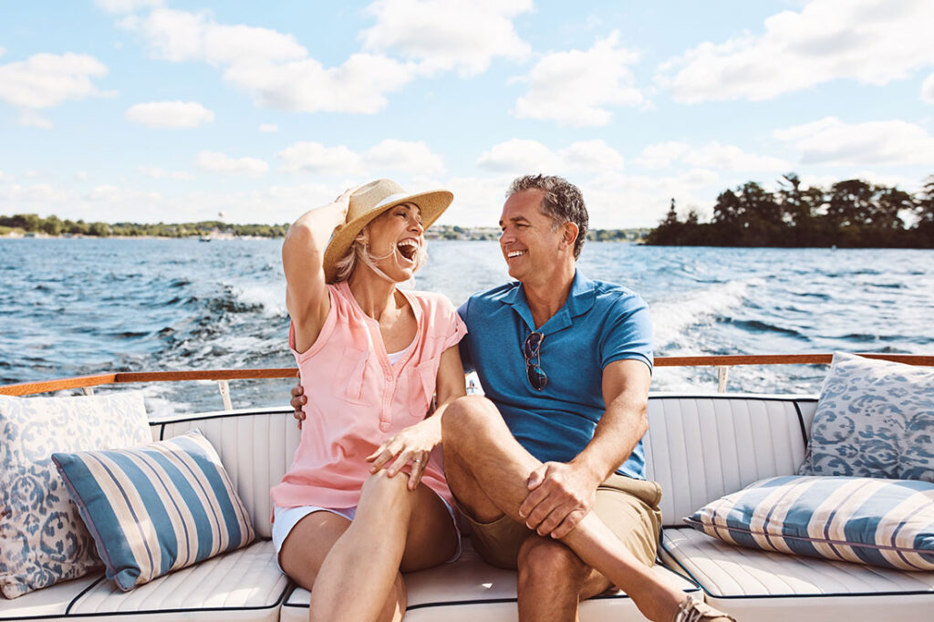 A laughing, happy couple on a boat for retirement