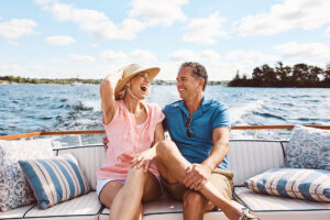 A laughing, happy couple on a boat for retirement