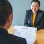 A woman sits across from a man in a job interview.